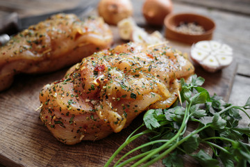 Spicy chicken breast with parsley and garlic on wooden board