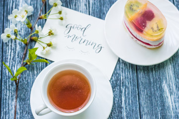 Still life with cup of tea and cake on the wooden background