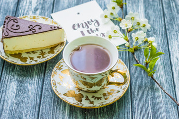 Still life with cup of tea and cake on the wooden background