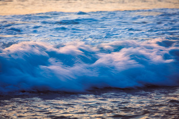 Sea wave on the beach at sunset