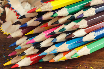 Heap of colored pencils, wooden background