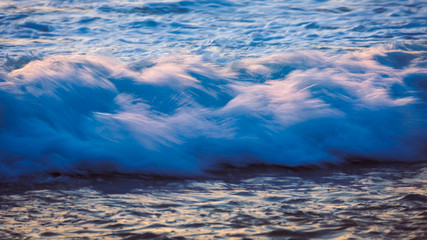 Sea wave on the beach at sunset