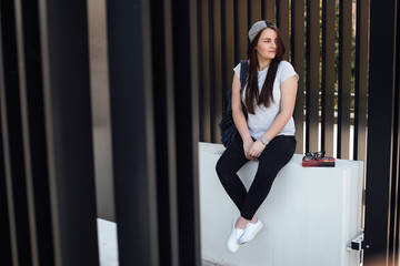 Pretty girl sit on the steps and read book with headphones