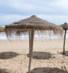 Awning from the sun made of straw and wood on the seashore