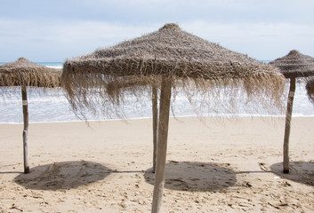Awning from the sun made of straw and wood on the seashore