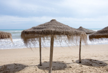 Awning from the sun made of straw and wood on the seashore