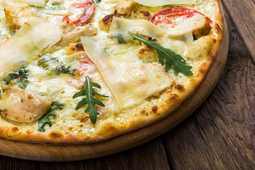 Delicious pizza with chicken, parmesan and fresh arugula