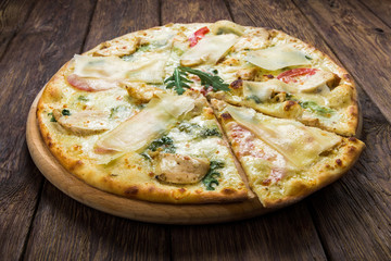 Delicious pizza with chicken, parmesan and fresh arugula