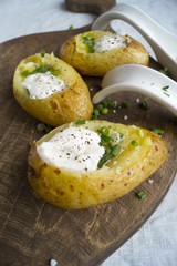 Spicy baked potatoes on wooden Board, closeup