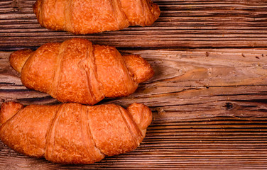 Fresh croissants on wooden table. Top view
