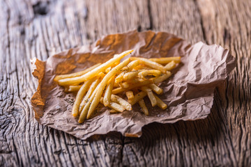 Potato fries. Gold potato fries with salt and dry herbs on wooden board.