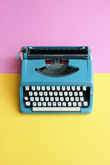 Vintage blue typewriter over a pastel background with room for copy.