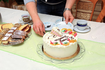 Tort urodzinowy i ciasta na stole, krojenie tortu.