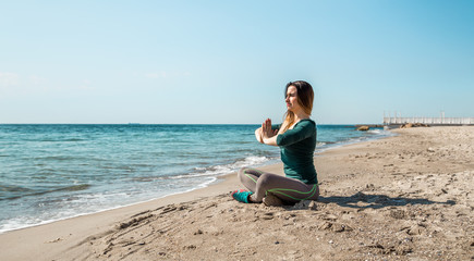 Girl in sportswear fitness by the sea listening