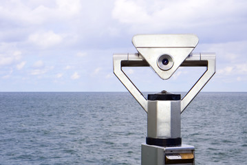 Ein M&uuml;nzfernrohr ist auf das weite Meer gerichtet. Ein Ausblick in die endlose Ferne &uuml;ber dem Wasser.