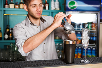 Barman making cocktail with lime