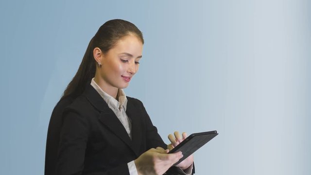 young business woman working on tablet and smiling on a blue background