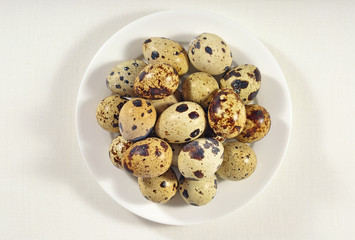 Quail eggs in a white bowl in a sacking