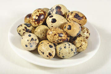 Quail eggs in a white bowl in a sacking