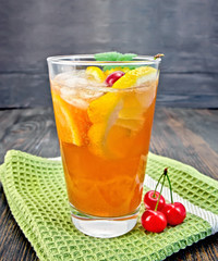 Lemonade cherry and orange in glassful on board