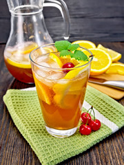 Lemonade with cherries in glassful and jug on board