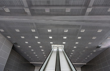 Fototapeta premium Futuristic metal escalator for lifting people in a modern shopping mall 