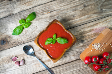 Tomato soup on wooden table, top view, place for typography