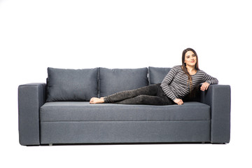 Obraz premium Young female lying on a sofa isolated on white background