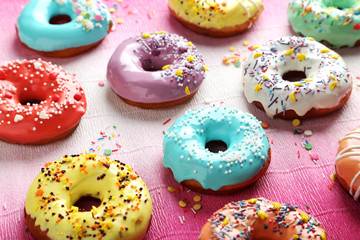 Tasty donuts with sprinkles on paper background