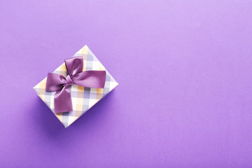 Gift box with ribbon on purple background