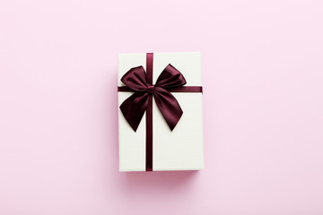 Gift box with ribbon on pink background