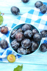 Tasty and ripe plums on blue wooden table