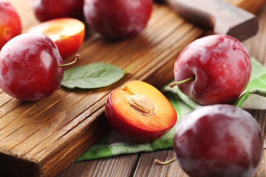 Fresh plums on a brown wooden table