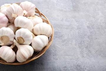 Garlic in basket on grey wooden table