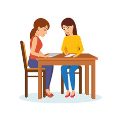 Girls sitting at table decide working moments, discuss, exchange materials.
