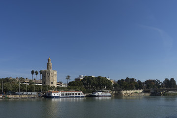 Obraz premium Torre del Oro junto al Guadalquivir en la ciudad de Sevilla, España