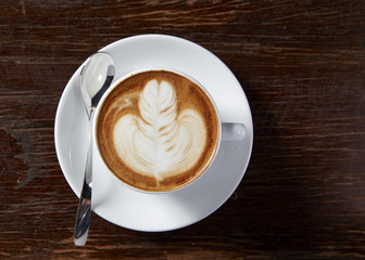 Cup of latte coffee on wooden table