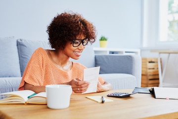 Young woman calcualting home finances, paying bills