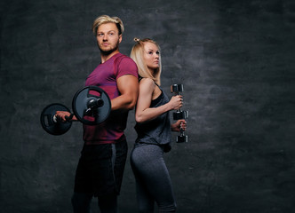Fototapeta na wymiar Attractive sporty couple over grey background.