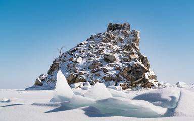 Small rocky island cover with snow in Frozen Lake Baikal