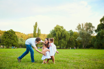 Fototapeta premium Happy family playing with children in the park