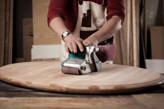 Carpenter Grinding Wooden Table