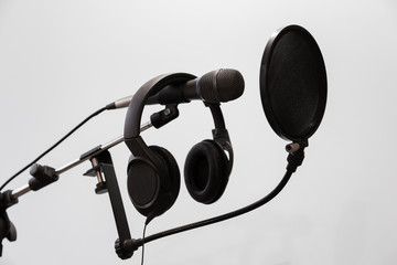 Cardioid condenser microphone, headphones and pop filter on a gray background. Home recording Studio. - obrazy, fototapety, plakaty