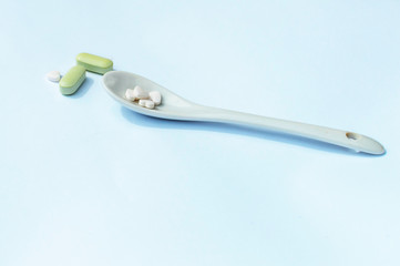 spoon and pills on a white background