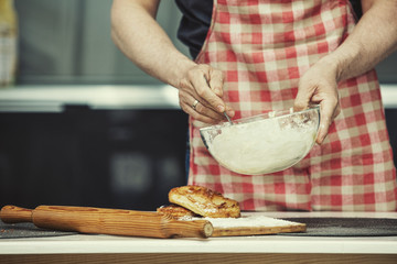 Hands closeup of a chef who makes the dough in the kitchen