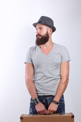 Portrait of handsome bearded man in hat standing with bag, isolated on white background
