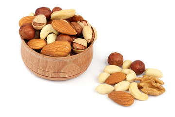 mix almonds, cashew nuts, hazelnut, peanuts, walnuts, pistachio in wood plate isolated on white background