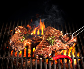Beef T-bone steaks on the grill - obrazy, fototapety, plakaty