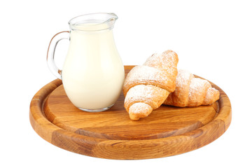 fresh croissant with jug milk on wood background