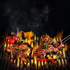 Tuinposter Beef T-bone steaks on the grill © Alexander Raths